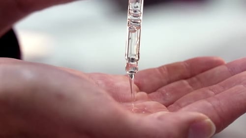 Serum Dropper Dispenses Clear Liquid on Hand