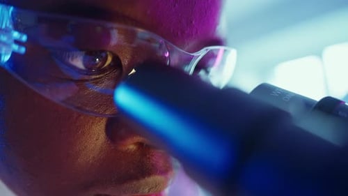 Close Up Scientist Using a Microscope in Lab