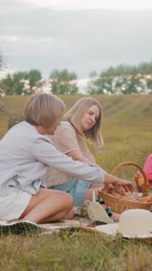 Family Picnic on Grassy Field with Hay Bales