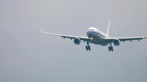 Airplane flying through the gray sky