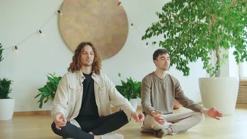 Two Men Meditating Calmly in an Indoor Setting