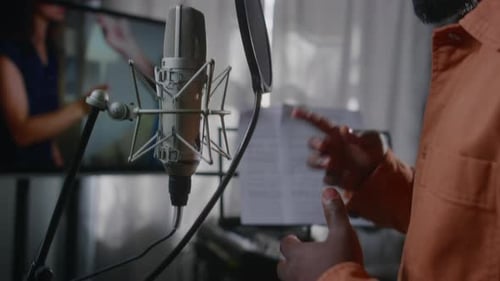 Hands of Black Male Voice Actor Dubbing Emotional Movie Scene in Studio