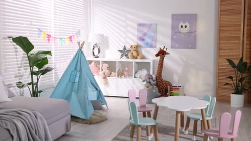 Chambre d'enfant avec wigwam en peluche, drapeaux colorés et lumières décoratives. La caméra avance