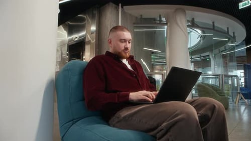 Man Using Laptop Freelancing in Modern Coworking Space