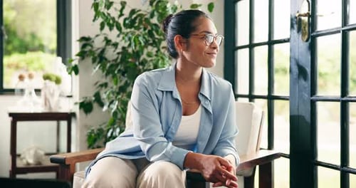 Smiling Woman Sitting in Chair near Window Inside Home