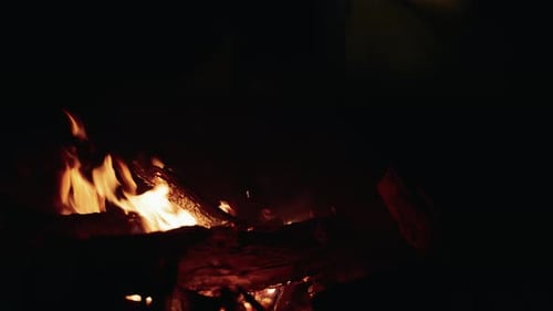 Nachtfeuer mit aufgebautem Zelt im Hintergrund