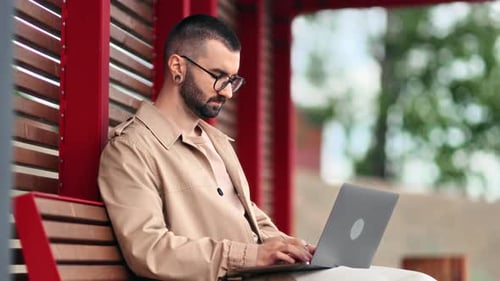 Skilled Male Business Freelancer Developer Programmer Working Laptop on Wooden Bench at Summer Park