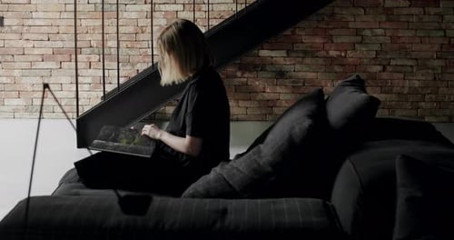 Woman Looks Through Photo Album in Urban Loft
