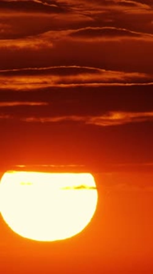 Vertical Sun: Striking Sunrise with Linear Clouds