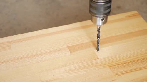 09f. Drill a hole in the board with a drill. Carpentry works. A tool for working with wood.