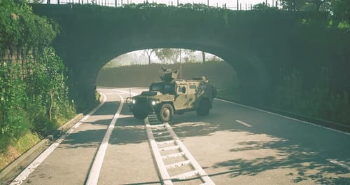 Military Vehicle Navigating a Winding Road Under an Old Stone Archway