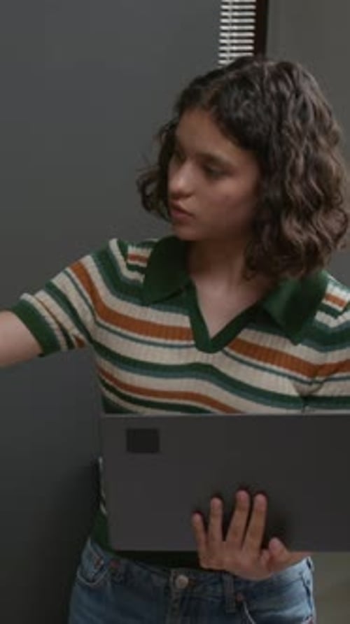 Vertical of Teenage Girl with Laptop Participating in Discussion at Lesson