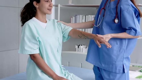 physical therapist anonymous Helping a temporarily paralyzed patient lift his arms back and forth to