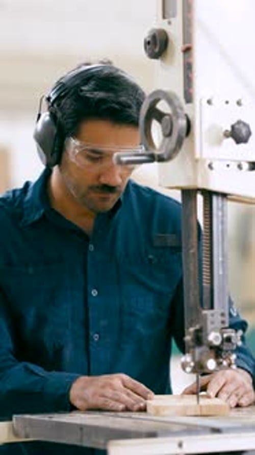 Professional Carpenter Cutting Wood with Bandsaw Vertical