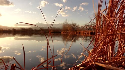 Reflection of sunset and clouds over lake surface