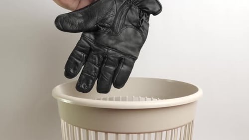 Black Gloves Thrown into Trash Can