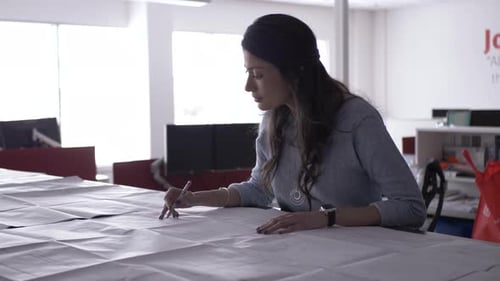 Designerin arbeitet an Architekturplänen im modernen kanadischen Studio
