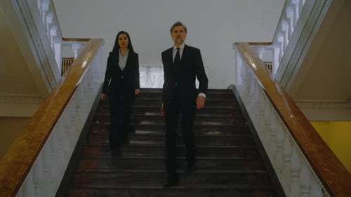 Man and Woman Answer Questions From Press