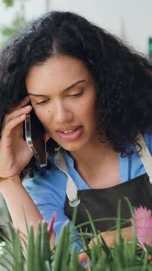 Woman Talking on Phone Caring for Flower