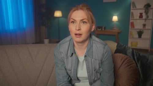 Portrait of a Woman Sitting on the Couch Watching TV Close Up A Woman Watches a Movie Series Reality