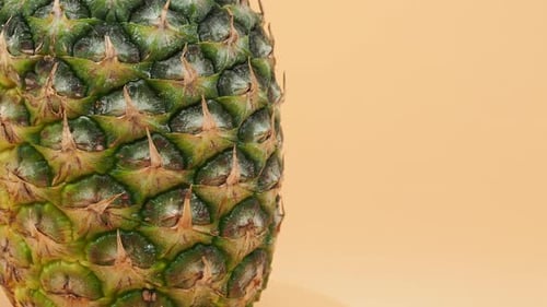 Close-Up of Green Pineapple on Light Orange Background