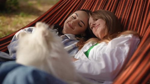 Women Relaxing in Hammock with Dog Outside
