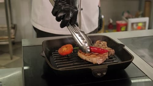 Chef Grilling Steak and Vegetables on Pan