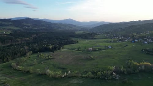 Mountains landscape during a summer day with mountains peaks, forest, lush greenery and trees