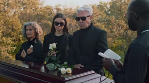 Family Members Putting White Roses on Coffin During Funeral Service