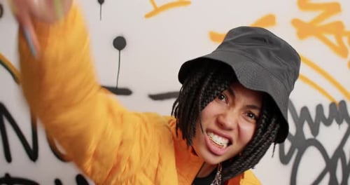 Energetic hip hop teenager dances freely against a graffiti wall in New York City