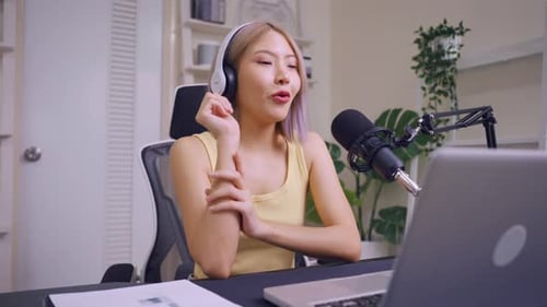 Woman Podcasting Into Microphone At Her Desk