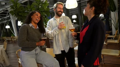 Modern People Drinking Beer at Terrace of Bar at Night