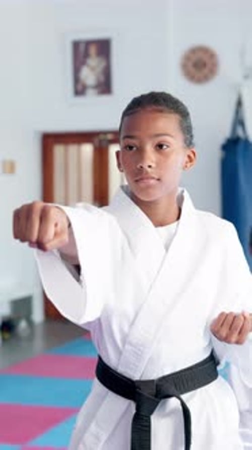 Teen Girl Practicing Karate in Dojo