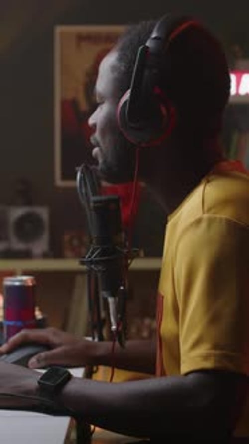 Man at Computer Recording Audio Using Microphone