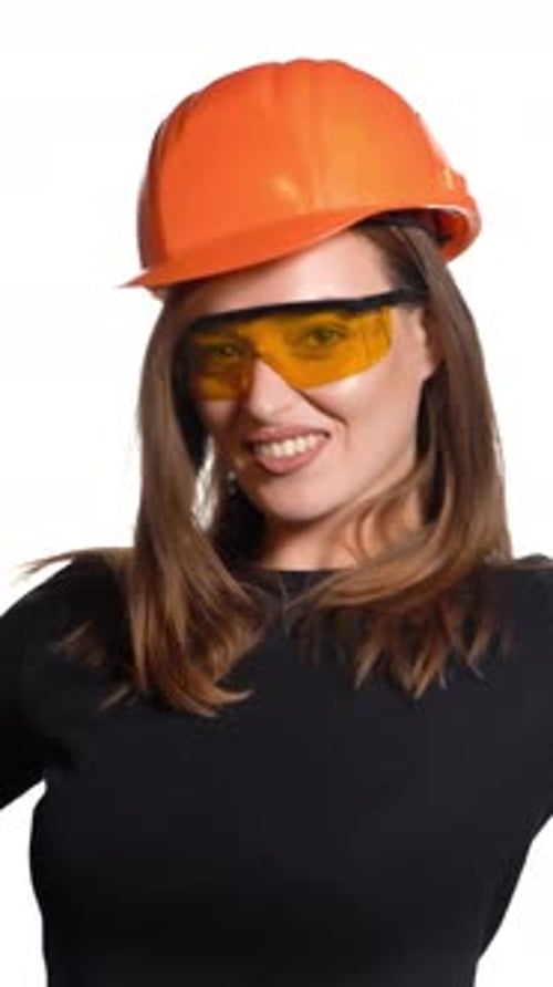 Una mujer bonita con casco naranja y anteojos