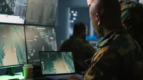 Military Personnel Analyze Data on Computers in Secure Office
