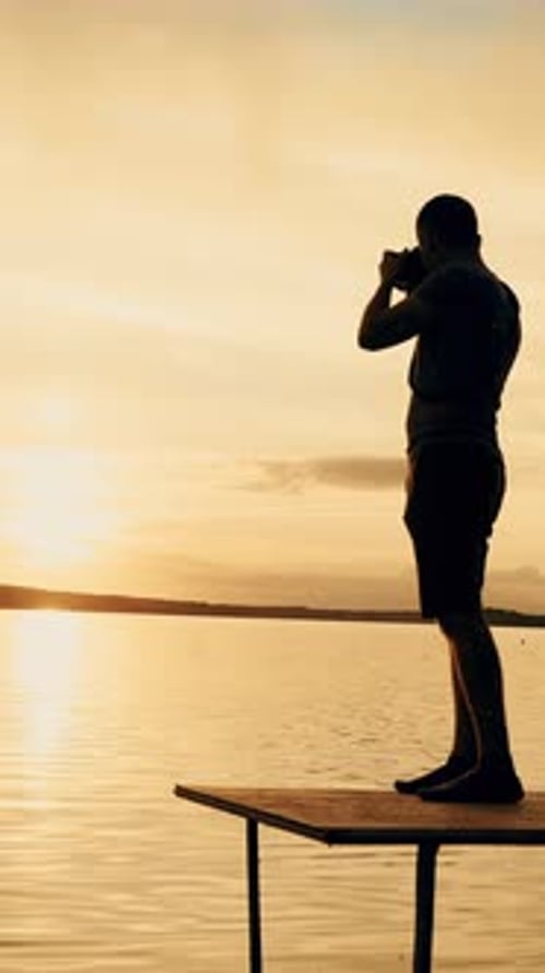 Fotograf fotografiert Landschaft bei Sonnenuntergang.