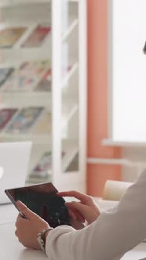 Person Using Tablet Device at Desk Indoors
