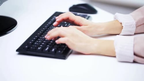 Une femme tape à la main sur un clavier d'ordinateur dans une technologie de bureau moderne