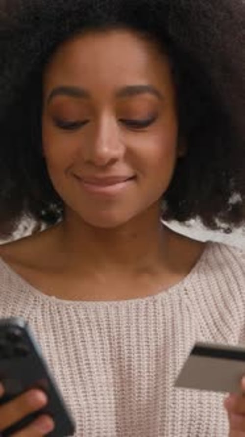 Woman uses a smartphone and credit card