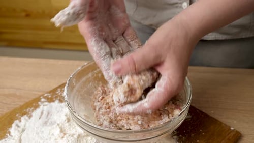 Hands Mixing Meat with Flour in Bowl