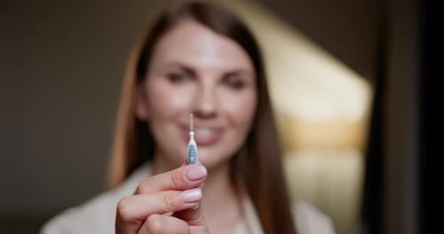 Woman Holding Interdental Brush for Braces