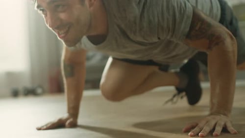 Slow Motion Close Up of a Muscular Fit Man in T-shirt and Shorts is Doing Mountain Climbers While U