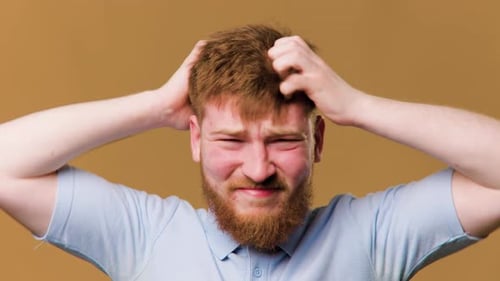 A Studio Shot of a Guy with a Head Full of Itchy Hair Scratching His Scalp in Discomfort