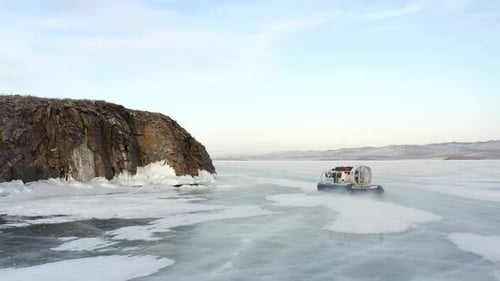 An air cushion boat rushes at high speed across the frozen Lake Baikal