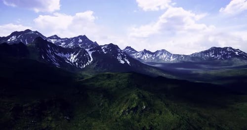 Majestic Mountain Range Under a Clear Sky Showcasing Lush Greenery