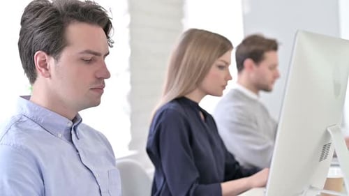 Focused Startup Team using Laptops in Modern Office