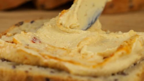 Hummus Being Spread on Whole Wheat Bread