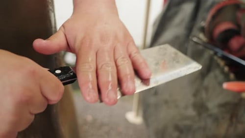 Gros plan des mains inspectant un couteau couperet chinois fraîchement nettoyé en Malaisie