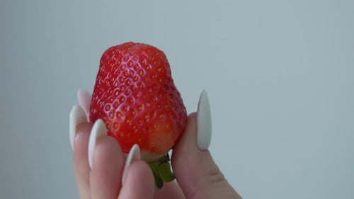 Close-Up of Strawberry Held in Hand